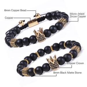 Matte black stone and gold crown bracelet set with zircon inlays on white background