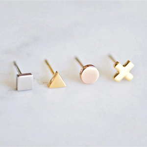 Close-up of geometric titanium steel studs in square, triangle, circle and cross shapes