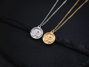 Vue détaillée de pendentifs pièces en or 18 carats et argent sur surface en pierre