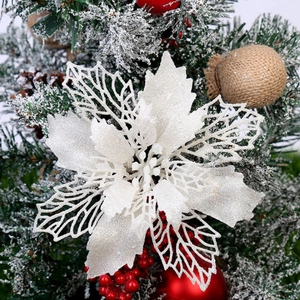 Macro detail of glittering white Christmas flower decoration on a snowy pine branch