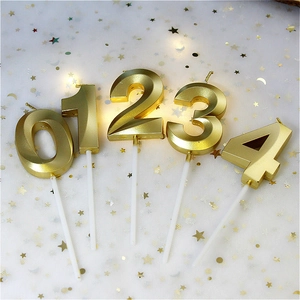 Elegant gold numeral birthday candles 0-4 with metallic finish on white sequined fabric