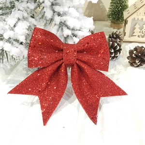 Sparkling red Christmas bow for tree decoration set against a festive snowy background