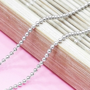 Dettaglio della collana a sfere in argento sterling 925 lucido su un tappetino di bambù