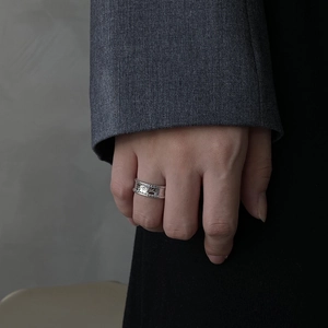 Minimalist 925 sterling silver ring with engraved letters worn on a model's finger