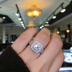 Close-up of cushion cut halo ring featuring double micro-pave diamonds on silver band