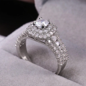 Macro side view of a round cut halo diamond ring in a grey velvet jewelry box
