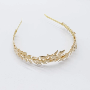 Detailed close-up of golden leaf pattern on a bridal headband with metallic texture