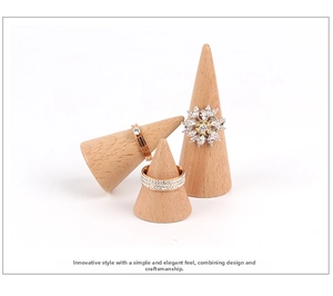 Three rose gold rings set with cubic zirconia on wooden cone display stands