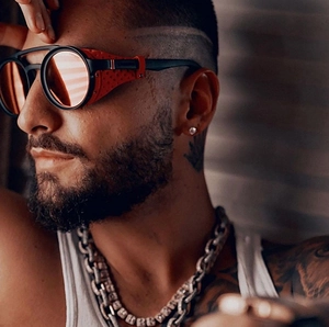 Close-up of retro punk sunglasses with leather side shields and silver Cuban chain necklace
