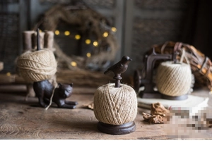 Vintage cast iron garden twine holders with decorative bird and cat motifs on wood