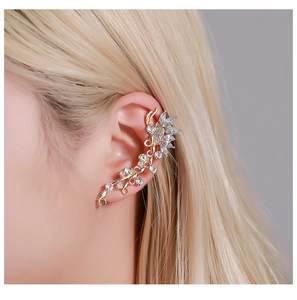 Macro view of gold ear crawler featuring crystal butterfly and floral petal accents