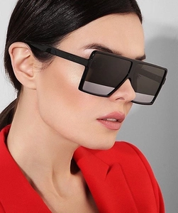 Close-up of black oversized square sunglasses with thick frames on fashion model