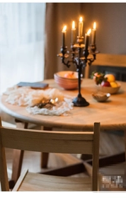 Macro-opname van rustieke gietijzeren kandelaar op een minimalistische ronde houten eettafel