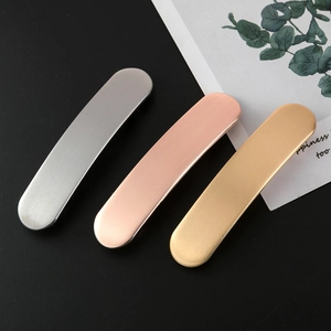 Tre fermagli per capelli ovali in metallo opaco argento oro e oro rosa su nero