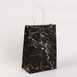 Close-up of black marble pattern paper gift bag with durable white rope handles