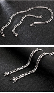 Detail of silver stainless steel Cuban link chains with dragon head clasp closure