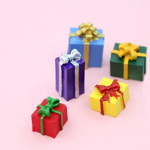 Five colorful resin mini gift box models with ribbons on a pink background