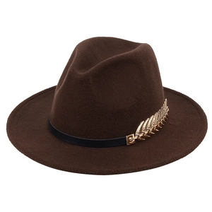 Close-up of a brown wool fedora hat featuring a black band and gold metal leaf accessory