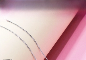 Macro shot of silver S925 curb chain necklace showing dense links and bright metallic texture