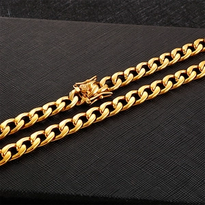 Golden stainless steel Cuban link necklace with classic box clasp on black background