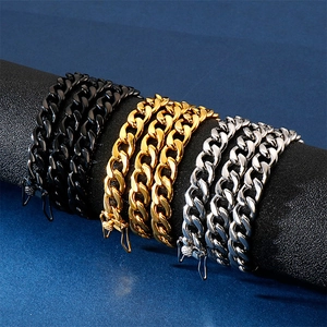 Cuban link necklaces in black, gold, and silver finishes on a textured cylindrical display