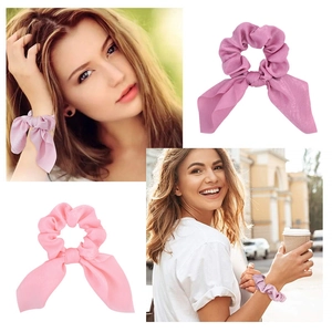 Dettaglio di elastici per capelli in raso rosa e viola con fiocco e texture lucida