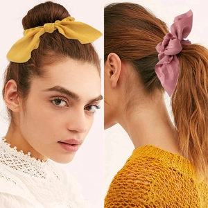Dettaglio degli elastici per capelli in raso giallo e rosa con eleganti fiocchi