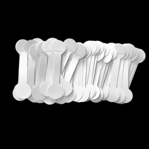 Close-up of bone-shaped white paper jewelry price tags stacked on a black background