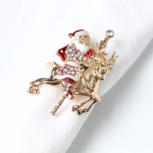 Detail of golden Santa and reindeer napkin ring with red enamel and crystals