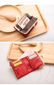 Detail of red vintage short wallet showing kiss-lock clasp and multi-card slots interior
