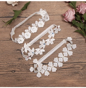 Detailed macro of three white lace headbands featuring pearls, rhinestones and flowers