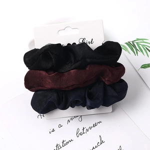 Three-piece satin scrunchies set in black, wine red, and navy blue on display card