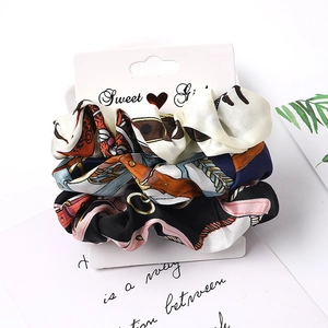 Three-piece satin scrunchie set with retro floral prints on elegant display card