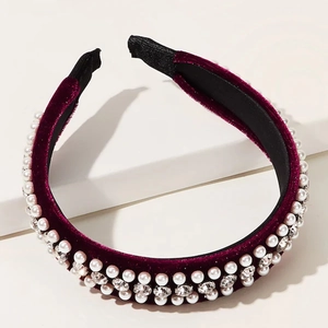 Close-up of burgundy velvet headband with double-row white pearls and clear rhinestones