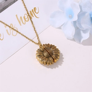 Gros plan du pendentif tournesol en or vintage avec texture et pétales superposés