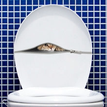 Detail of 3D orange cat zipper sticker on white toilet lid with blue mosaic wall background