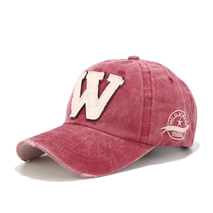 Detail of vintage red washed cotton baseball cap with embroidered W patch and star logo