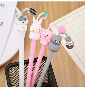 Close-up of four cute cartoon animal pens with silicone charms on a wooden desk