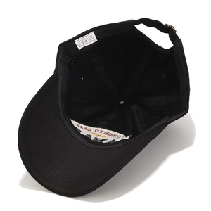 Detail of 100% cotton baseball cap interior with wash label and adjustable metal buckle