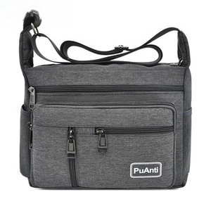 Close-up of waterproof dark gray crossbody bag with multiple zippers and side pocket
