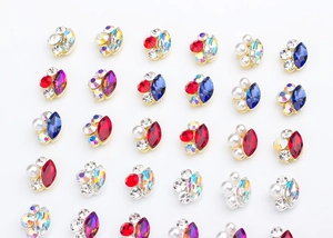 Macro shot of horse eye rhinestone nail charms with metal edging and pearls