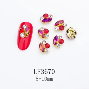 Macro detail of 8x10mm alloy nail art charms with red marquise crystals and gold edging