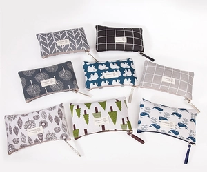 Detailed set of 8 linen makeup bags with zipper closures and natural themed prints