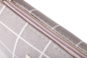 Detail of high-quality zipper and grey grid fabric texture on large capacity makeup bag