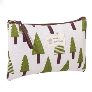 Close-up of canvas makeup bag showing green tree patterns and natural style label