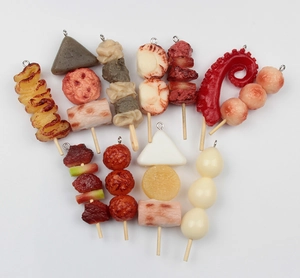 Detailed view of assorted miniature Japanese food charms like oden and yakitori skewers