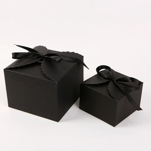 Close-up of black gift boxes with square bases and elegant matching silk ribbons