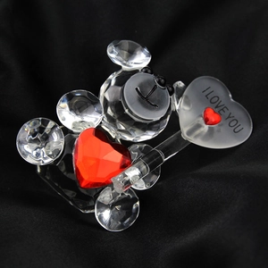 Close-up of crystal bear ornament holding a red heart and I LOVE YOU sign on black fabric