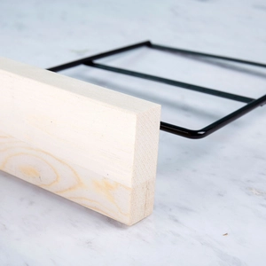 Detail of the pinewood base and black metal frame of the earring display stand