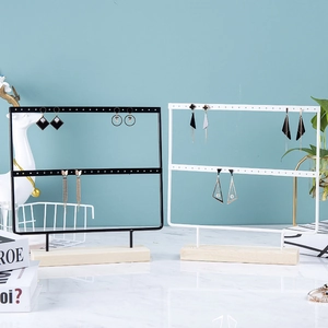 Double-tier metal earring holder stand in black and white with a solid wood base